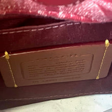 Load image into Gallery viewer, Close-up of a red leather-bound book with gold text and decorative elements.