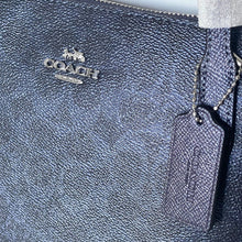 Load image into Gallery viewer, Close-up of a Coach handbag with visible branding.