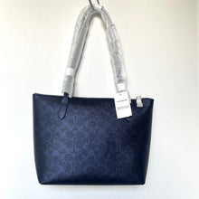 Load image into Gallery viewer, Navy blue handbag with a visible Coach tag on a white background