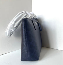 Load image into Gallery viewer, Navy leather handbag with a visible brand tag on a white surface.