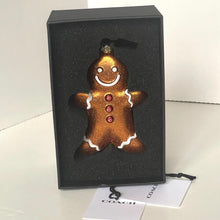 Load image into Gallery viewer, Gingerbread man ornament in a Coach box with a Coach tag.