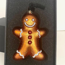 Load image into Gallery viewer, Gingerbread man ornament with a smiley face on a black background