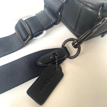 Load image into Gallery viewer, Black leather bag with strap and visible brand logo on a light background