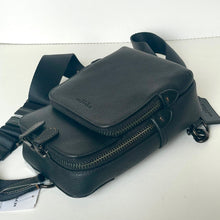 Load image into Gallery viewer, Black leather crossbody bag with visible brand name on a white background