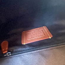 Load image into Gallery viewer, Brown leather patch with text on a dark fabric surface