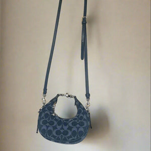 Blue handbag with a strap on a light beige background