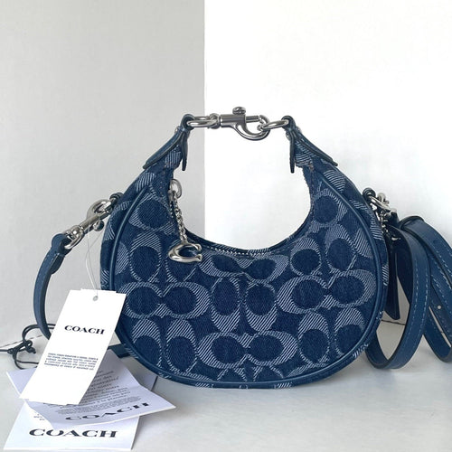 Blue Coach handbag with a matching strap on a white background