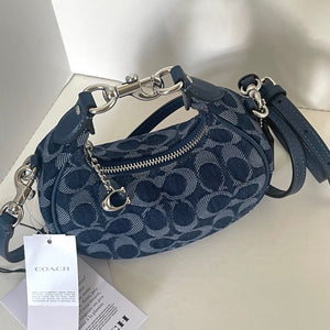 Blue Coach handbag with a tag on a light background