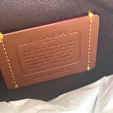 Load image into Gallery viewer, Coach bag with brown leather label on a dark background