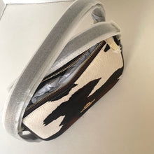 Load image into Gallery viewer, Clutch bag with black abstract design and silver strap on a light background