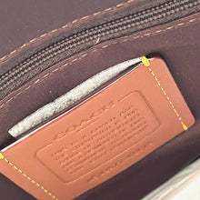 Load image into Gallery viewer, Close-up of a Coach wallet with a visible brand label.