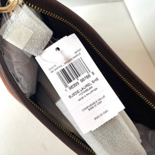 Load image into Gallery viewer, Close-up of a product tag inside a brown leather bag on a white background
