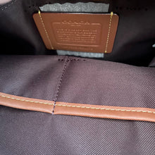 Load image into Gallery viewer, Close-up of a brown leather label on a textured fabric surface