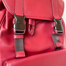 Load image into Gallery viewer, Close-up of a red backpack with straps and buckles.