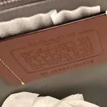 Load image into Gallery viewer, Brown leather book with embossed text on a gray surface
