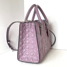 Load image into Gallery viewer, Purple handbag with embossed logo on a white background