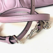Load image into Gallery viewer, Close-up of a pink leather handbag with silver hardware on a white background