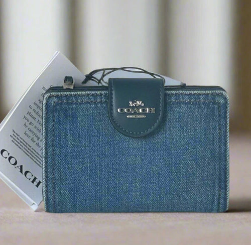 Blue Coach wallet with a matching cardholder on a light gray surface.