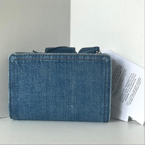 Blue denim wallet on a light gray surface with a white background