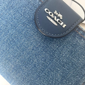 Close-up of a Coach logo on a denim surface