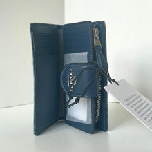Load image into Gallery viewer, Blue wallet with a visible brand tag on a white background
