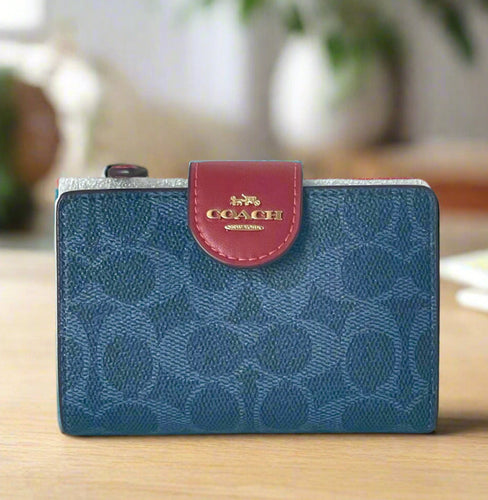 Blue Coach wallet with a red flap on a white background