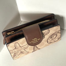 Load image into Gallery viewer, Coach wallet with starfish pattern on a white background