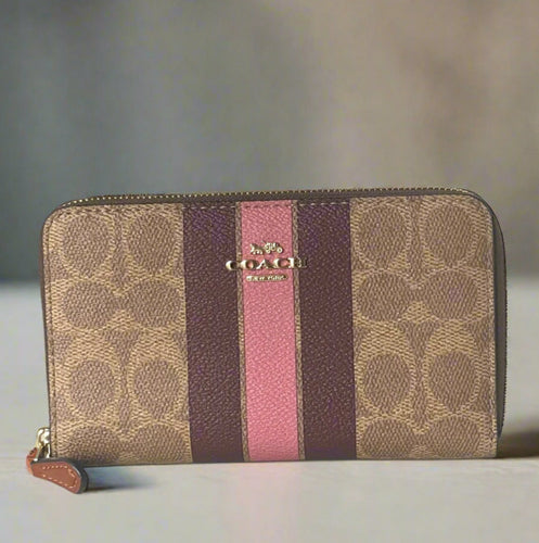 Coach wallet with brown, purple, and pink stripes on a white background