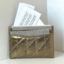 Load image into Gallery viewer, Gold quilted cardholder with silver interior holding papers against a neutral background