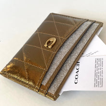 Load image into Gallery viewer, Brown quilted leather wallet with gold emblem on a white surface with Coach branding.