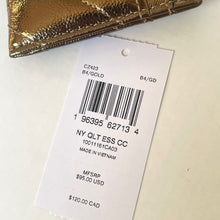 Load image into Gallery viewer, Gold clutch with a label on a white background