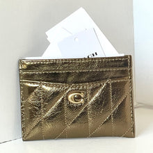 Load image into Gallery viewer, Gold quilted cardholder with Coach logo on a white background