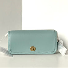 Load image into Gallery viewer, Light blue pouch with a gold clasp on a light gray background