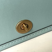 Load image into Gallery viewer, Close-up of a gold lock on a light blue and white leather product