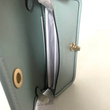 Load image into Gallery viewer, Light blue handbag with gold accents on a white background