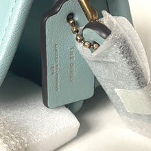 Load image into Gallery viewer, Light blue keychain with gold beads on a white surface