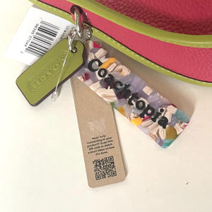 Colorful keychain with a tag and barcode on a pink background
