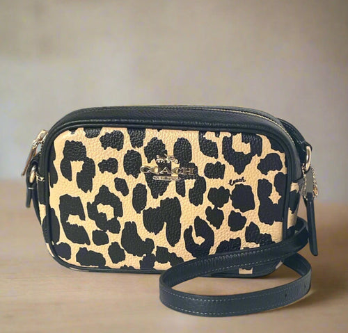 Leopard print handbag with black accents on a white background