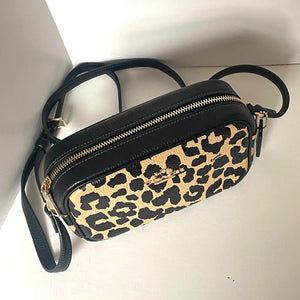 Leopard print handbag with black strap on a white background
