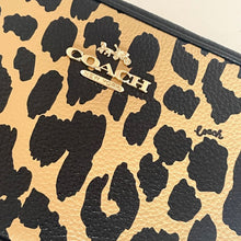 Load image into Gallery viewer, Leopard print clutch with Coach logo on a beige background