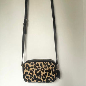 Leopard print crossbody bag on a plain background