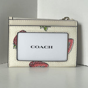 Coach wallet with floral design on a white surface