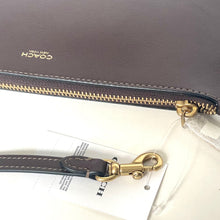 Load image into Gallery viewer, Coach handbag with gold zipper and strap on a white background
