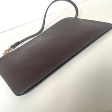 Load image into Gallery viewer, Brown leather clutch bag with a strap on a light gray background