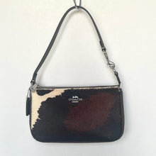 Load image into Gallery viewer, Coach handbag with cow print pattern on a white background