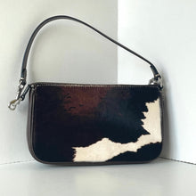 Load image into Gallery viewer, Handbag with black and white cowhide pattern on a light background