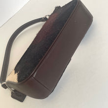 Load image into Gallery viewer, Brown leather bag with a black and white fur interior on a light gray background