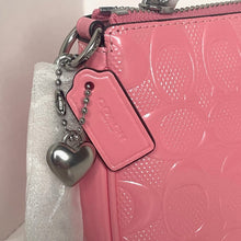 Load image into Gallery viewer, Pink textured handbag with a heart-shaped tag and keychain on a white background