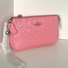 Load image into Gallery viewer, Pink Coach wristlet with a clear plastic bag on a white background
