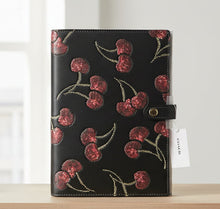 Load image into Gallery viewer, Black notebook with red cherry pattern on a white background